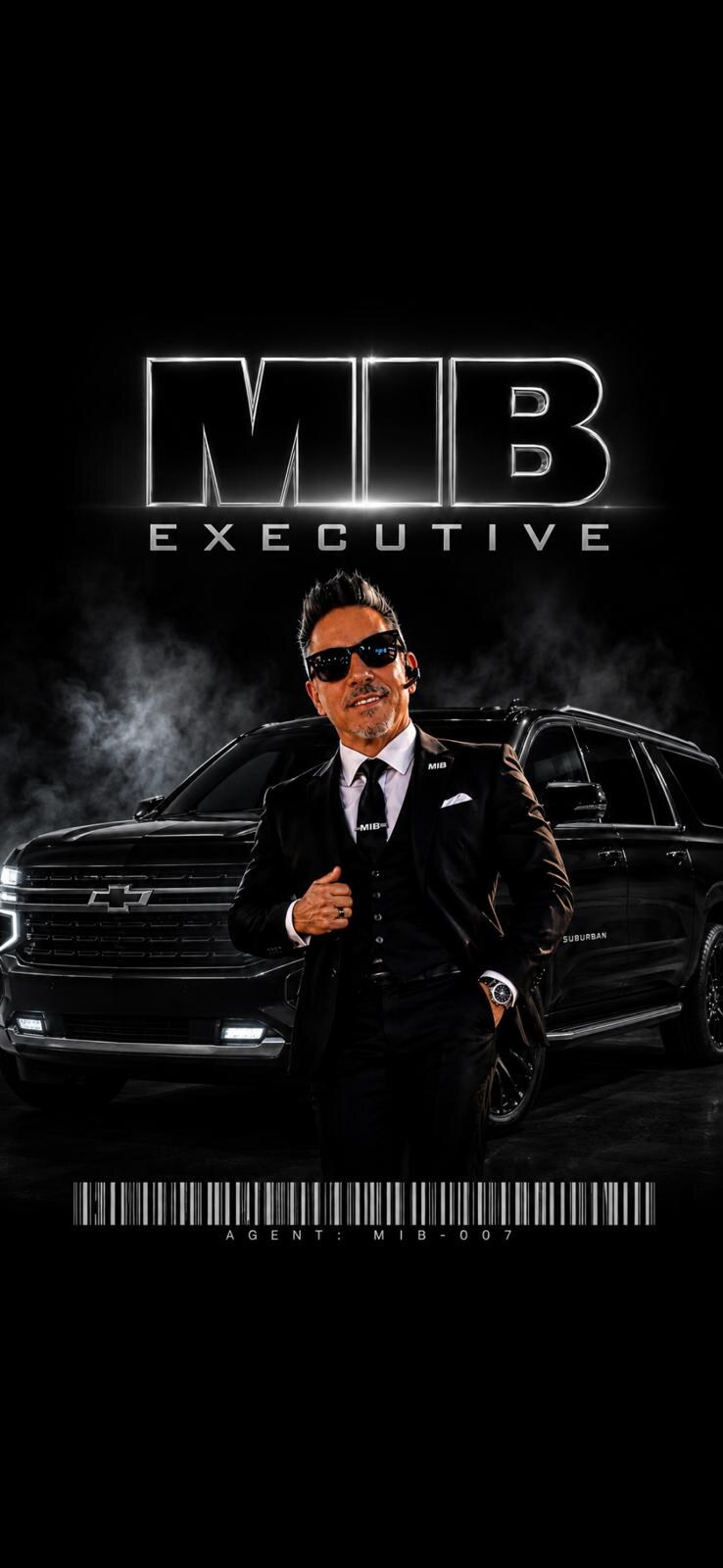 Kenneth Heffernan in a black suit beside the black-on-black Chevrolet Suburban RST under the MIB Executive wordmark