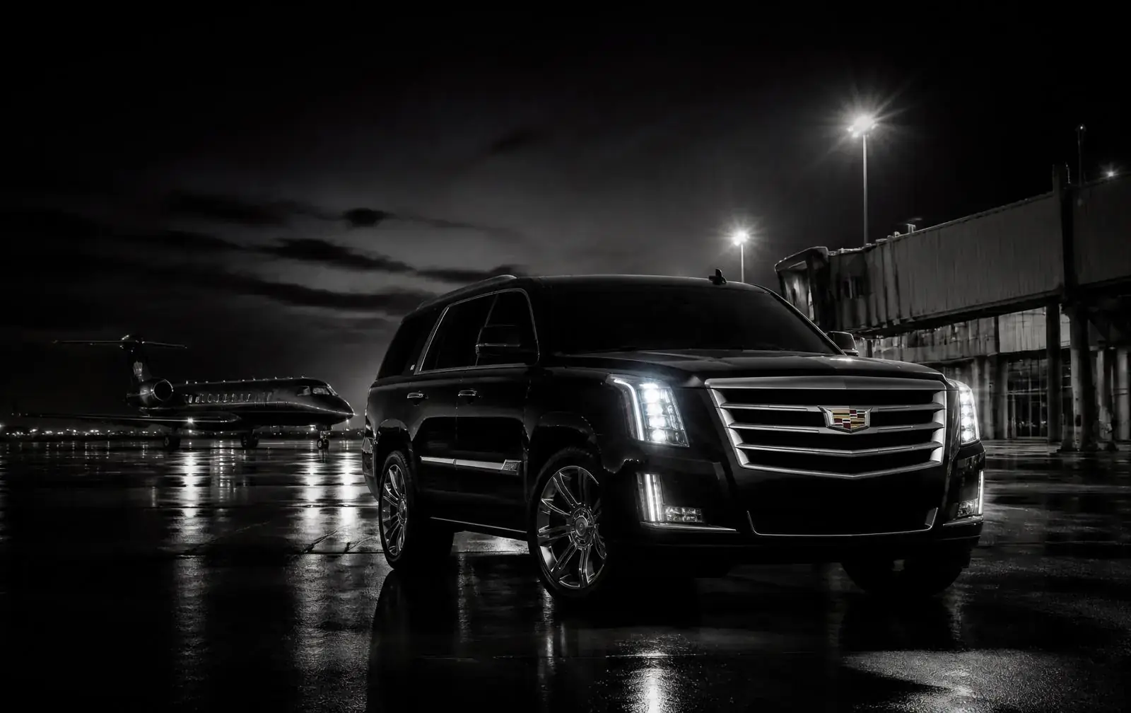 Executive SUV waiting outside an airport terminal at night